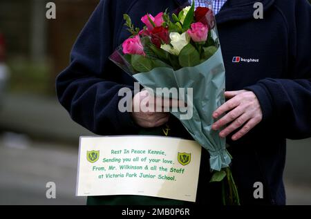 Aktenfoto vom 24.01/22, von einem Mitglied der Öffentlichkeit mit Blumen auf der Thirlmere Avenue in Stretford, Manchester. Die Polizei von Greater Manchester bietet eine Belohnung von £50.000 Dollar für Informationen, die zu einer Verurteilung des Mordes an dem 16-jährigen Kennie Carter führen werden. Kennie wurde am 22. Januar letzten Jahres auf der Thirlmere Avenue in Stretford tödlich in die Brust gestochen. Ausgabedatum: Freitag, 20. Januar 2023. Stockfoto