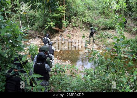 Mitglieder der philippinischen Küstenwache und deren philippinische Nationalpolizei - Maritime Group, 2. Partner der Sondereinsatzeinheit überqueren einen Bach, während sie sich ihrem Ziel nähern während einer demonstrierten Razzia, die von Polizeihauptmann Valeriano de Leon und Green Berets mit 1. Spezialeinsatzkräften (Airborne) am 9. Juni 2022 in der Nähe von Puerto Princesa, Palawan, durchgeführt wurde. Dieses Engagement bot den Partnern die Möglichkeit, Taktiken, Techniken und Verfahren untereinander auszutauschen, um die Interoperabilität zu verbessern und gleichzeitig ihre Fähigkeiten zu demonstrieren. Unsere Verbündeten und Partner sind unsere Stockfoto