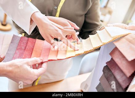 Mode, Hände und Damen mit der Materialauswahl für die Farbe in der Werkstatt. Teamarbeit, Zusammenarbeit und Planung von Designerinnen oder Schneiderinnen, die wählen Stockfoto