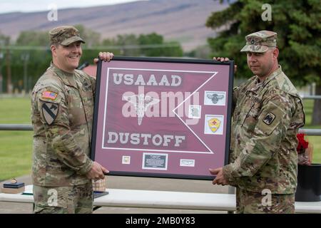 Major Jason West, ehemaliger Befehlshaber der USA Army Air Ambulance Detachment Yakima, 2-158. Helikopterbataillon, 16. Kampfluftfahrtbrigade erhält ein Geschenk von seinen Soldaten vor der Zeremonie des Kommandowechsels im Yakima Training Center, Washington, am 9. Juni 2022. Stockfoto