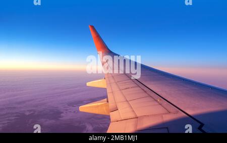 Panoramablick auf die Kabine durch ein Flugzeugfenster. Flugzeugflug über Land und blauer Himmel mit Platz für Text Stockfoto