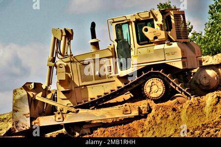 Ein Ingenieur Soldier der 157. Manöverbrigade der Wisconsin National Guard betreibt am 9. Juni 2022 im Rahmen eines laufenden Truppenprojekts in Fort McCoy, Wisconsin, einen Bulldozer, der Erde bewegt. Das Projekt befindet sich in einem Gebiet in der Nähe des alten Tores 20 und der verbesserten taktischen Ausbildungsbasis Liberty und des Zauns des Kantonationsgebiets, so Larry Morrow, Koordinator für Truppenprojekte der Direktion für öffentliche Arbeiten von Fort McCoy (DPW). Der Standortplan sieht vor, dass es sich um einen Basisstandort für den Betrieb von Servicetechnikern wie z. B. Anlagenwartung, Straßen und Grundstücke, Festmüll, Hausrat handelt Stockfoto