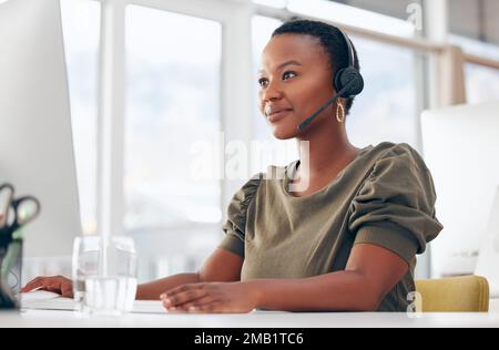 Sie ist dran. Eine Geschäftsfrau, die ein Headset trägt, während sie an ihrem Computer arbeitet. Stockfoto