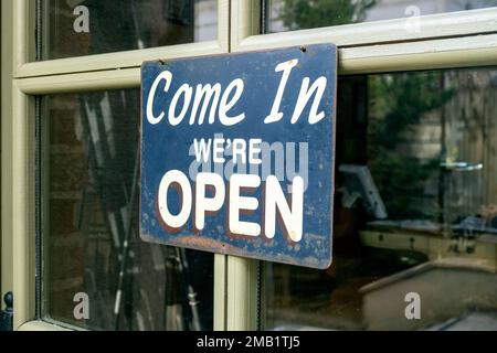 Kommen Sie rein, wir sind offen - Text auf einem Schild des Cafés Stockfoto