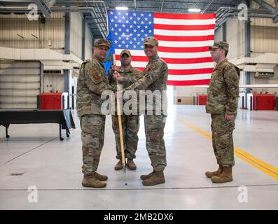 USA Oberst Jason Dillon (links) der Luftwaffe, Befehlshaber der 319. Einsatzgruppe, erhält den Guidon aus den USA Oberstleutnant William Harrell, ausscheidender Kommandant des 319. Flugzeuginstandhaltungsgeschwaders, während der 319. AMXS-Zeremonie in einem Hangar am 10. Juni 2022 am Luftwaffenstützpunkt Grand Forks, North Dakota. Als Kommandant führte Harrell fast 600 Luftwaffenstützpunkt Grand Forks und seine geografisch getrennten Einheiten an. Stockfoto