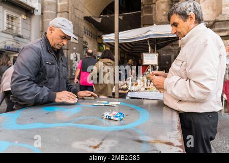 Italien, Kampanien, Neapel: Einheimische spielen Karten auf der piazza Dante am Eingang von Port'Alba Stockfoto