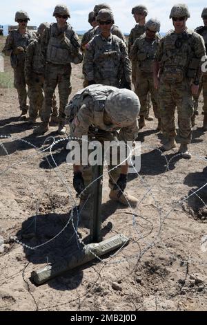 Eine Gruppe von Kampftechnikern der 833. Engineer Company, Iowa National Guard, beobachtet, wie während des Western Strike 22, 10. Juni 2022, im Orchard Combat Training Center, Idaho, ein vorbereiteter C4-Sprengstoff auf den Konzertina-Draht gelegt wird. WESTERN Strike 22 ist eine exportierbare Kampfübung unter der Leitung der 65. Artilleriebrigade, Utah National Guard, die Soldaten der Nationalgarde in einem Tauchtraining ähnlich einem Kampftrainingzentrum ausbildet und darauf abzielt, die Bereitschaft und die Letalität der teilnehmenden Einheit zu erhöhen. Stockfoto