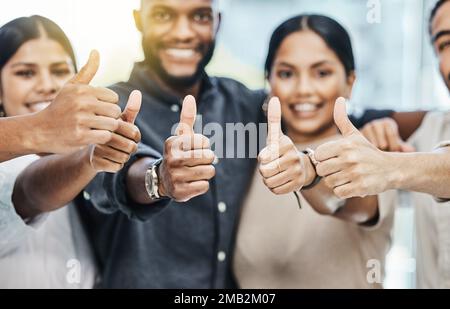 Was für ein erfolgreicher Arbeitstag. Eine Gruppe von Geschäftsleuten, die gemeinsam die Daumen nach oben drücken. Stockfoto
