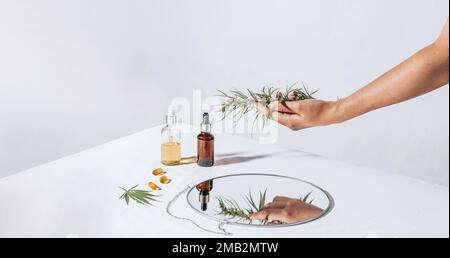 Cannabis in der Hand. Pharmazeutische Pillen, Kapseln auf einem weißen Tisch. Konzept Melatoninproduktion und Wiederherstellung des Schlafrhythmus. Blätter, cbd-Öl Stockfoto