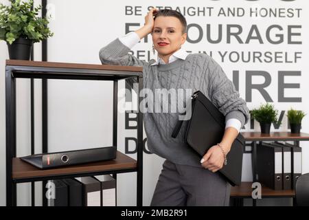 Versicherungsagentin mit Papiermappe im Büro Stockfoto