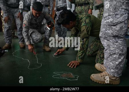 Mitglieder der philippinischen National Police - Maritime Group, der 2. Special Operations Unit und der philippinischen Spezialeinsatztruppe der Küstenwache planen einen Besuch, ein Einsteigen, eine Such- und Beschlagnahmungsdemonstration am 10. Juni 2022 in der Nähe von Puerto Princesa, Palawan. Dieses Engagement bot der 1. Special Forces Group (Airborne) Green Berets Gelegenheit, Taktiken, Techniken und Verfahren mit ihren philippinischen Partnern auszutauschen, um die Interoperabilität zu verbessern und gleichzeitig neue Ideen für maritime Einsätze auszutauschen. USA Die Sondereinsatzkräfte bereiten sich weiterhin auf die Herausforderungen von morgen vor und ergreifen sie Stockfoto