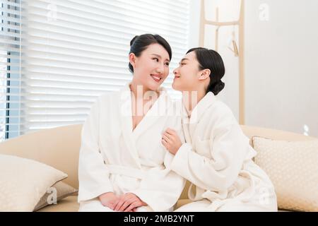 Mutter und Tochter, zwei Leute im Bademantel saßen am Fenster Stockfoto
