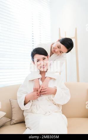 Mutter und Tochter, zwei Leute im Bademantel saßen am Fenster Stockfoto