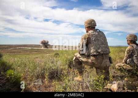 Kampftechniker mit der 833. Engineer Company der Iowa National Guard aus Ottumwa, Iowa, beobachten am 10. Juni 2022 im Orchard Combat Training Center in Idaho aus sicherer Entfernung eine Explosion auf einem Abbruchgelände. Die Soldaten reisten nach Idaho, um an einer exportablen Übung zur Kampfausbildung, oder XCTC, teilzunehmen, die Western Strike genannt wird. Ziel der Übung war es, die Kampfbereitschaft und die Letalität der Einheit zu erhöhen. Stockfoto