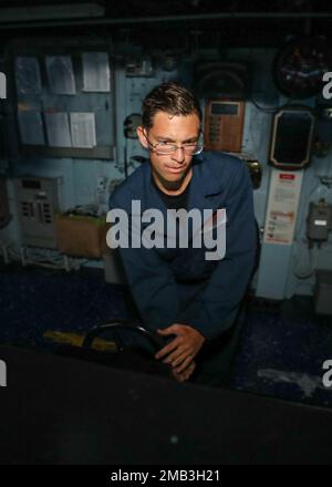 PHILIPPINE SEA (10. Juni 2022) Boatswain's Mate Seaman Patrick Seyler, von St. George, South Carolina, ruder im Pilothouse an Bord der Arleigh-Burke-Klasse-Guided-Missile Destroyer USS Benfold (DDG 65). Benfold ist dem Kommandeur, der Task Force (CTF) 71/Destroyer Squadron (DESRON) 15, der größten nach vorn eingesetzten DESRON der Marine und der Hauptstreitkräfte der US-7.-Flotte zugewiesen. Stockfoto