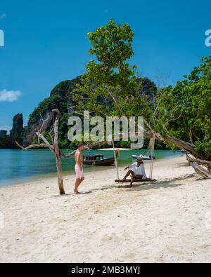 Die Insel Koh Phakbia liegt in der Nähe von Koh Hong Krabi, einem wunderschönen weißen Sandstrand in Krabi Thailand. Junge asiatische Frauen und europäische Männer am Strand während des Thailandurlaubs. Stockfoto