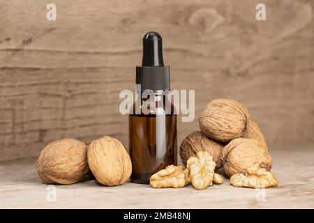 Walnussöl-Stillleben. Braunglasflasche mit Pipettennussöl Stockfoto