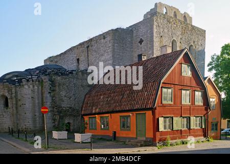 Kleines rotes Haus vor der mittelalterlichen Kirchenruine, Ostsee, Visby, Gotland, Schweden Stockfoto