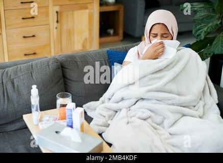 Kann diese Grippe Geh weg. gefallen Eine attraktive junge Frau, die allein auf ihrem Sofa zu Hause sitzt und sich krank fühlt. Stockfoto