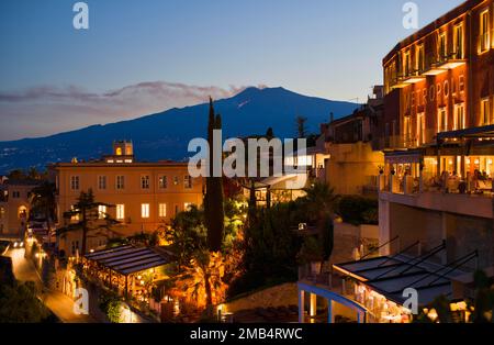 Blick auf das Hotel Metropole und San Domenico Palace Four Seasons, Ätna mit seitlicher aktiver Lavafissur, Eruptionswolke, Dämmerung, Taormina, Sizilien, Italien Stockfoto