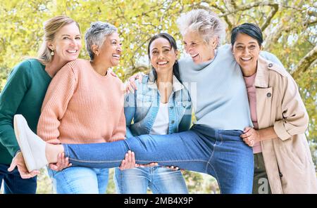 Seniorinnen, Porträt und lustiger Spaß beim Binden, Comic-Spielen und alberner Energie-Aktivität im Naturpark, Garten und Umgebung. Lächeln, glücklich und Stockfoto
