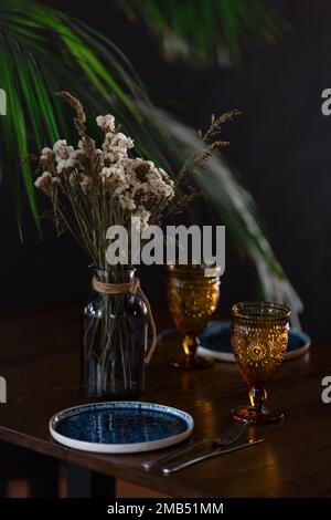 Köstlicher Rosenwein in Gläsern, frische rote Erdbeeren in einer Tasse und einer Schüssel und viele Pfingstrosen in Burgunder- und Rosa-Farben. Hochwertiges Foto Stockfoto