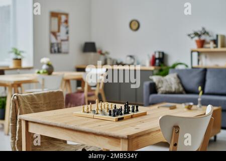 Schachbrett zum Spielen auf Holztisch im modernen Wohnzimmer Stockfoto