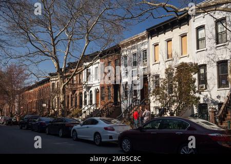 Männer, die sich vor einer Reihe von Wohngebäuden in Park Slope, Brooklyn, New York unterhalten Stockfoto