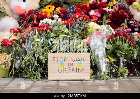 Spielzeug und Blumen liegen an einer Trolleybushaltestelle neben einem Haus, das während des Krieges von einer russischen Rakete auf Pobeda in der Stadt Dnepr in der Ukraine in die Luft gejagt wurde, dem M. Stockfoto