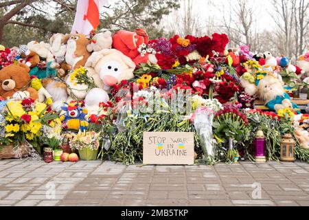 Spielzeug und Blumen liegen an einer Trolleybushaltestelle neben einem Haus, das während des Krieges von einer russischen Rakete auf Pobeda in der Stadt Dnepr in der Ukraine in die Luft gejagt wurde, dem M. Stockfoto