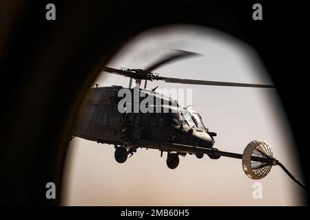 Ein 332d Air Expeditionary Wing HH-60G Pave Hawk Hubschrauber erhält Treibstoff von einem HC-130J Combat King II Flugzeug, das ebenfalls dem 332d AEW zugewiesen wurde, in Südwestasien, 12. Juni 2022. Die primäre Aufgabe des Pave Hawk besteht darin, Tag- oder Nachteinsätze zur Wiederherstellung von Personal in feindlichen Umgebungen durchzuführen, um isoliertes Personal während eines Konflikts zu erholen. Die HH-60G ist auch mit militärischen Operationen außer Konflikten beauftragt, einschließlich zivile Such- und Rettungsmaßnahmen, medizinische Evakuierung, Katastrophenhilfe, humanitäre Hilfe, Sicherheitskooperation/Luftverkehrsberatung, NASA Raumfahrt Unterstützung und Rettung c Stockfoto