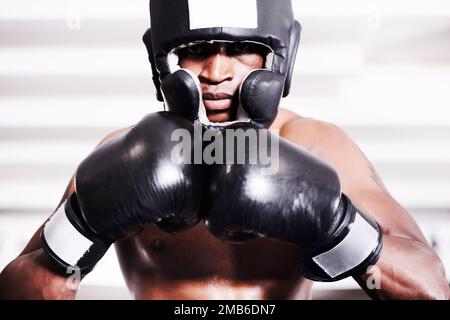 Gehen wir. Ein afroamerikanischer Boxer, der Schutzkleidung trägt und im Ring steht. Stockfoto