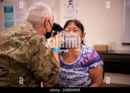 Oberstleutnant Mark Davis, Optometrist der 147. Attack Group, untersucht am 13. Juni 2022 die auf Kaua'i wohnhafte Corrina Digracia in Lihue, Hawai'i. Tropicare 2022 ist eine innovative Übungsübung zur Bereitschaftsplanung und bietet praxisnahe Schulungen in einem gemeinsamen zivilen und militärischen Umfeld und stärkt gleichzeitig die Gemeinschaftsbeziehung durch medizinische, zahnärztliche und optometrische Dienstleistungen für die Menschen von Hawai'i. Stockfoto