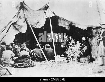 General William Sherman (dritter von links) und andere indische Friedenskommissare im rat mit einheimischen Häuptlingen und Headmen, anlässlich der Unterzeichnung des Vertrags von Fort Laramie im Jahr 1868 Stockfoto