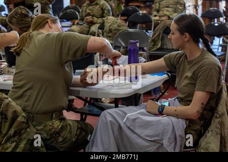 Angela Seliski, eine praktische Pflegefachkraft, legt eine simulierte Kampfwunde auf den Arm der PFC an. Deltann Pape, ein Ernährungsspezialist, der dem 256. Fight Support Hospital zugewiesen wurde, in Vorbereitung auf eine medizinische Veranstaltung im Rahmen der Übung Globale Medic-Trainingsübung in Fort Hunter Liggett, Kalifornien, Juni 13. Das Medical Readiness Training Command führt Übung Global Medic als Teil der größeren Mission des Army Reserve Medical Command durch, ausgebildete, ausgerüstete und kampfbereite Einheiten und medizinisches Personal zur Unterstützung der gesamten Truppe auf den Schlachtfeldern von heute A bereitzustellen Stockfoto