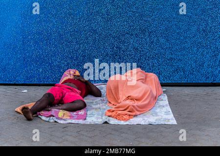 Salvador, Bahia, Brasilien - 09. Februar 2018: Zwei Straßenverkäufer schlafen nach der Karnevalsnacht in der Stadt Salvador in Bahia auf dem Boden. Stockfoto