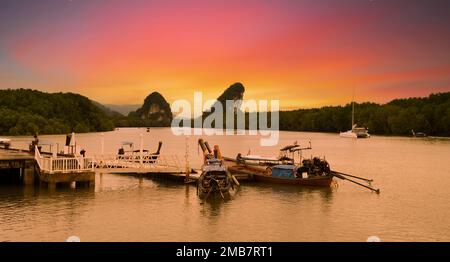 Sonnenaufgang in der Innenstadt von Krabi. Traditionelle Tourboote auf dem Fluss. Thailands beliebteste Reiseziele Stockfoto