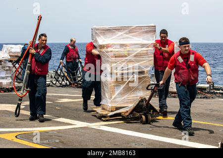 GOLF VON ADEN (13. Juni 2022) Seeleute transportieren Fracht während einer vertikalen Wiederauffüllung an Bord des kleinen Kampfschiffs USS Sioux City (LCS 11) im Golf von Aden, Juni 13. Sioux City wird im US-5.-Flottengebiet eingesetzt, um die Sicherheit und Stabilität des Seeverkehrs im Nahen Osten zu gewährleisten. Stockfoto