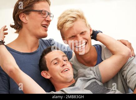 Eine ernsthafte Freundschaft. Drei junge Männer, die Spaß auf einem Outdoor-Festival haben. Stockfoto