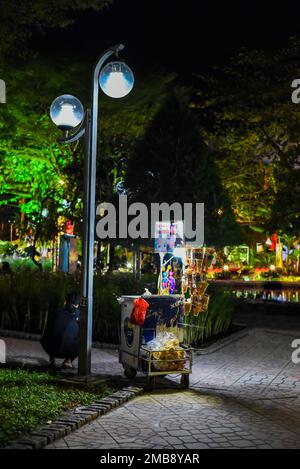 Nha Trang, Vietnam - 18. Januar 2023: Trolley mit Popcorn in der Nähe des vietnamesischen Verkäufers bei Nacht Stockfoto