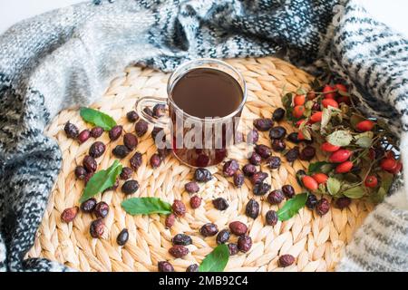 Rosehip-Tee, frisch gebrühter Obst- und Kräutertee, Bio-Rosehips im Hintergrund, Draufsicht. Stockfoto