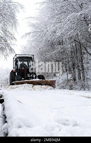 Ein Traktor, der Schnee von einer Bergstraße in den Karpaten in Polen schaufelt. Stockfoto