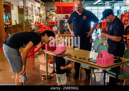 Memphis, Tennessee (13. Juni 2022) Mitglieder der Naval Support Activity Mid-South Fire Department sprechen mit Familien, die während der Navy Week Memphis das Feuermuseum von Memphis besuchen. Die Memphis Navy Week ist eine von 14 Navy Weeks im Jahr 2022, in der eine Vielzahl von Ressourcen, Ausrüstung und Personal in eine einzige Stadt gebracht wird, um eine Woche lang eine Reihe von Verlobungen abzuhalten, die die amerikanische Marine näher an die Menschen bringen sollen, die sie schützt. Jedes Jahr erreicht das Programm mehr als 140 Millionen Menschen – etwa die Hälfte der US-Bevölkerung. Stockfoto