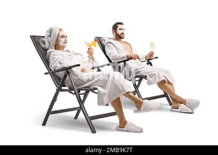 Mann und Frau mit kosmetischen Gesichtsmasken sitzen mit einem Cocktail und einem Glas Champagner isoliert auf weißem Hintergrund Stockfoto
