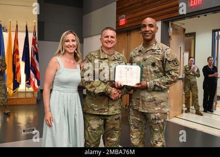 Oberst Tracy Michael (rechts), Fort George G. Meade Medical Department Activity Commander, überreicht den beförderten Oberstleutnant Johnathan Evans (Zentrum), den scheidenden Kommandeur der Barquist Army Health Clinic, mit einer Auszeichnung vor einer Zeremonie zum Kommandowechsel am 14. Juni 2022 in Fort Detrick Maryland. Stockfoto