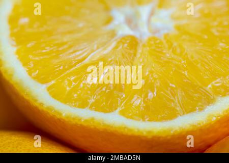 Ein Stück geteilte Orangenfrucht in einem appetitlich aussehenden Makrofoto. Stockfoto