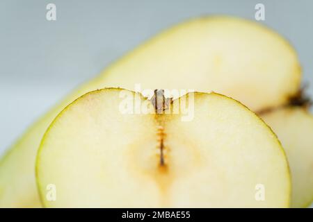 Birnenfrucht in zwei Hälften auf weißem Hintergrund in einem sehr nahen Foto. Stockfoto