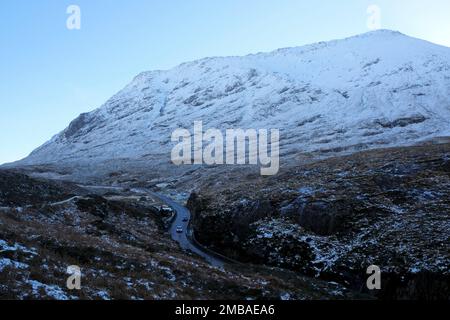 Glencoe, Schottland, Großbritannien. 20. Januar 2023 Der klare blaue Himmel, Sonnenschein und schneebedeckte Hänge der Berge rund um Glencoe bieten eine Kulisse für schwierige Fahrbedingungen auf der eisigen Hauptstraße A82 North. Kredit: Craig Brown/Alamy Live News Stockfoto