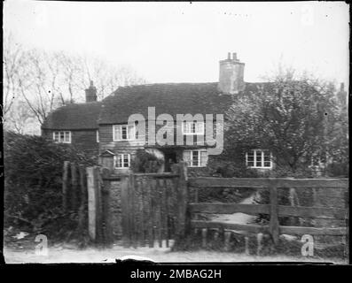 Winchelsea, Icklesham, Rother, East Sussex, 1905. Eine Hütte in der Nähe von Winchelsea über dem Gartenzaun. Dieses nicht identifizierte Cottage hat ein halbes Hüftdach und ist im ersten Stock mit Fliesen aufgehängt mit Wetterschutz im linken Bereich. Stockfoto