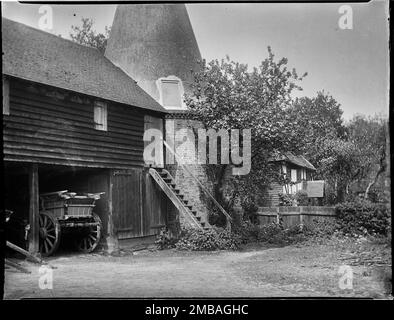 Florence Farm, Groombridge, Withyham, Wealden, East Sussex, 1911. Ein Außenblick vom Südosten des Oasthouse und der Stauscheune auf der Farm Florence, mit dem Holz umrahmten Haus, bekannt als Killiecrankie dahinter. Der Fotograf und zeitgenössische Postkarten bezeichnen das Haus als Killiecrankie, aber es scheint Pollies Hall zu zeigen, bevor es Anfang des 20. Jahrhunderts restauriert wurde. Stockfoto